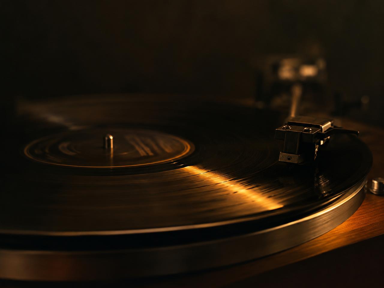 Vinyl record on a turntable in amber light